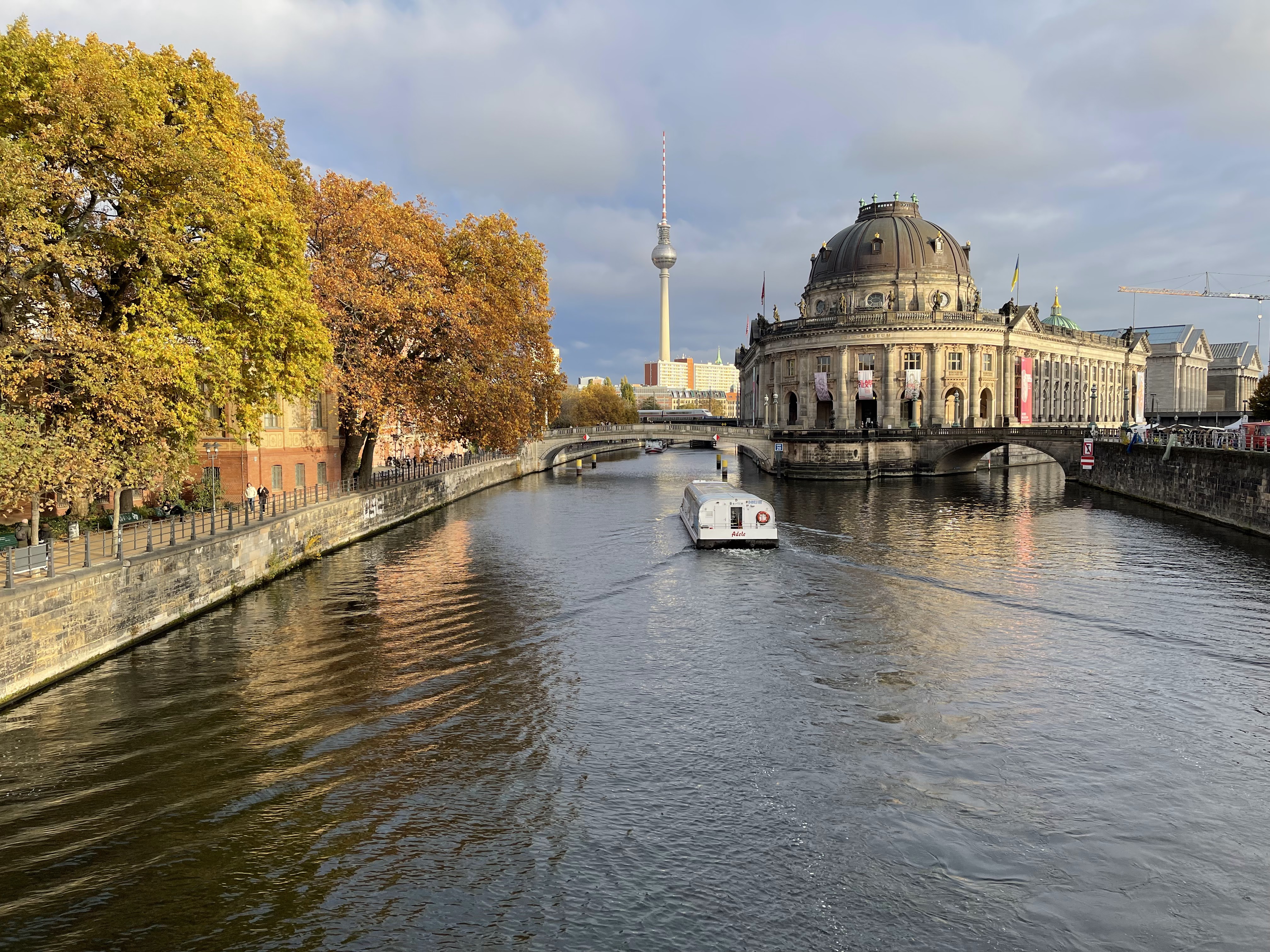 Pictureque view of a river boat, museum island, and TV tower in Berlin