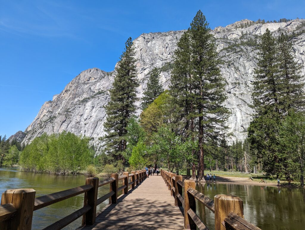 Swinging bridge leading to trees and mountains in Yosemite Valley. A definate first time visit in Yosemite activity